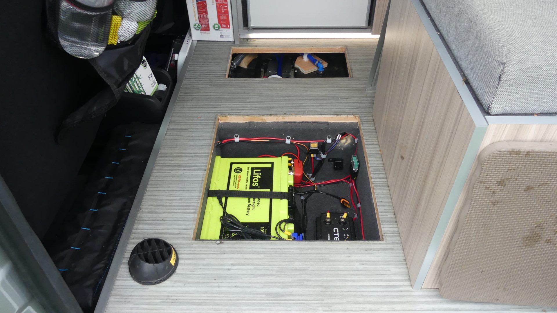 Leasure battery & Water Pump in floor in front of fridge